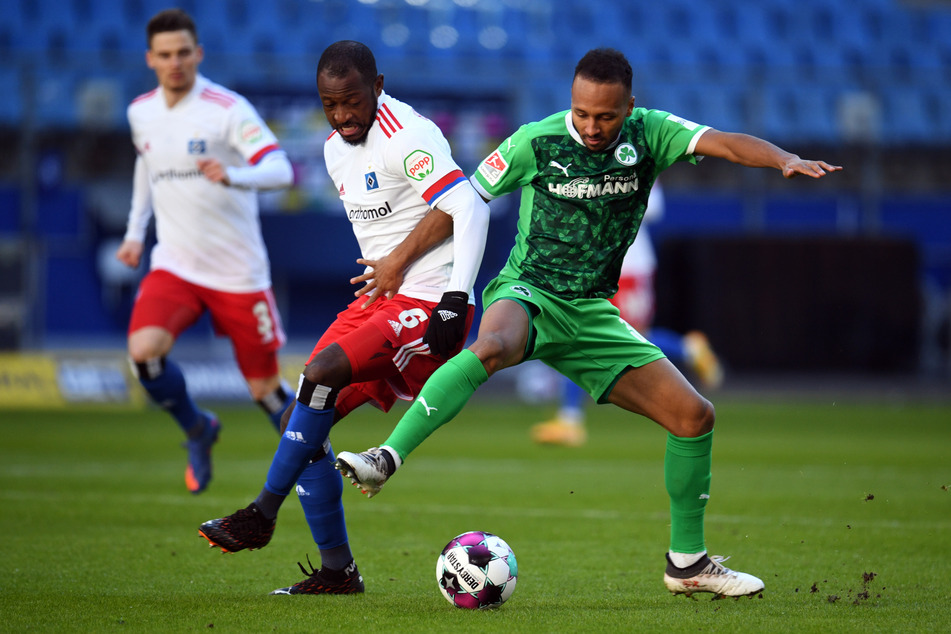 HSV-Mittelfeldspieler David Kinsombi (M.) und Greuther Fürths Julian Green kämpfen um den Ball.