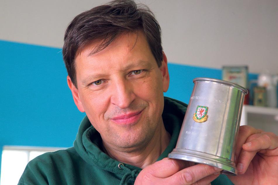 Jens Genschmar (52) von Dresdner Fußballmuseum zeigt den Zinnpokal, den Co-Trainer Werner Wolf von den Gästen aus Wales erhalten hatte.
