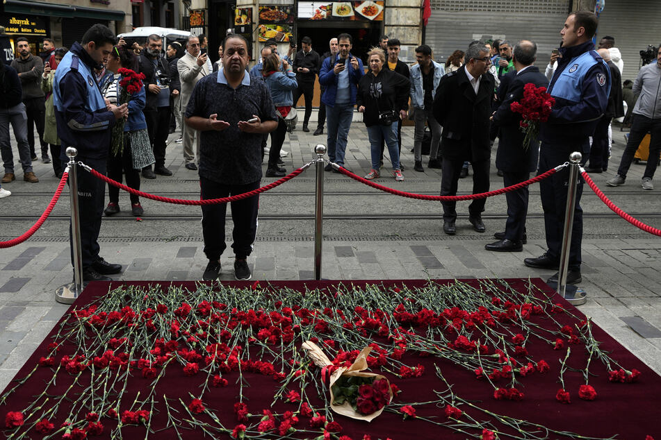 Ein Mann trauert am Ort der Explosion, immer wieder legen Menschen Blumen nieder.