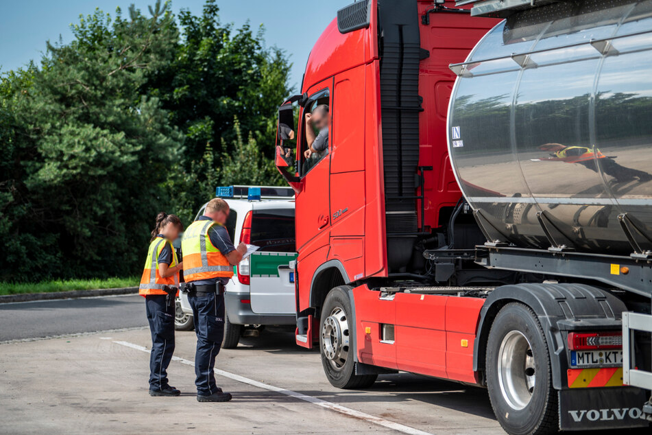 Die Zöllner befragen einen Lkw-Fahrer nach seinen Beschäftigungsverhältnissen.
