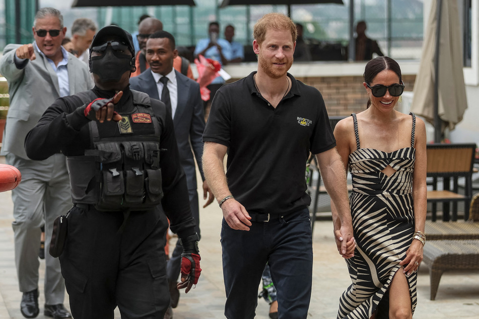 Prince Harry (c.) and Meghan Markle (r.) arrived in Nigeria on Friday for a three-day visit.