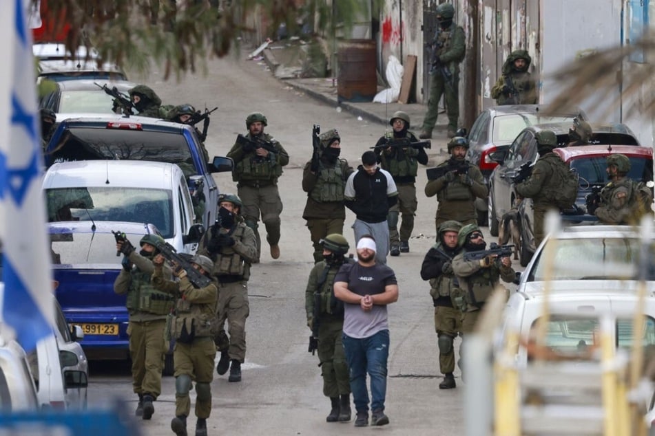 Israeli troops detain Palestinian men during a raid at the Al-Amari refugee camp near Ramallah, in the occupied West Bank.