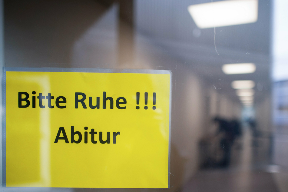 Ein Schild mit der Aufschrift "Bitte Ruhe!!! Abitur" hängt in einem Gymnasium.
