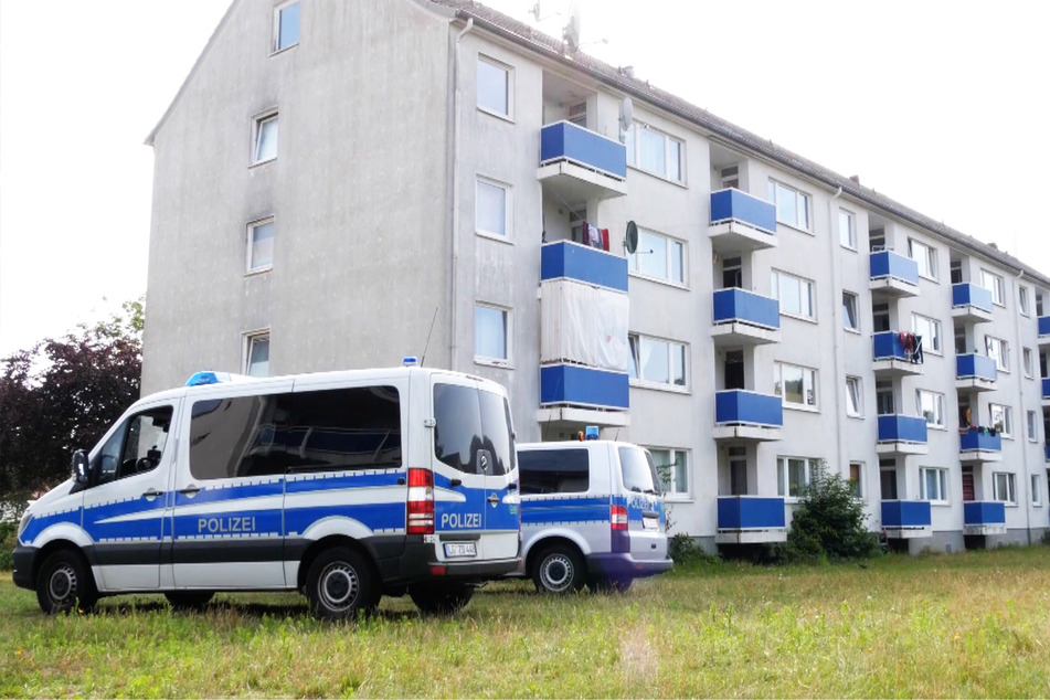 Polizeifahrzeuge stehen vor einem Häuserkomplex und kontrollierten die Ausgangssperre.
