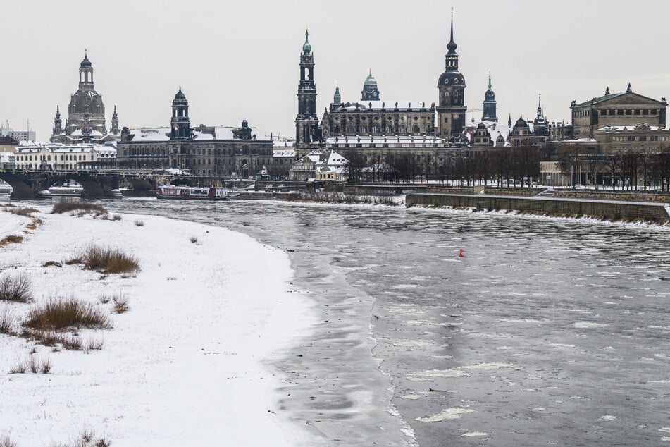 Eisschollen schwimmen auf der Elbe vor der historischen Altstadtkulisse Dresdens.