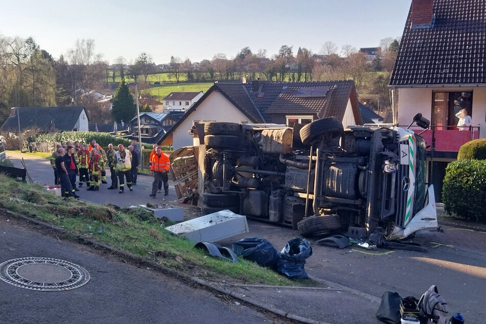 Der Müllwagen kippte bei dem Unfall um und blieb schließlich seitlich auf der Straße liegen.