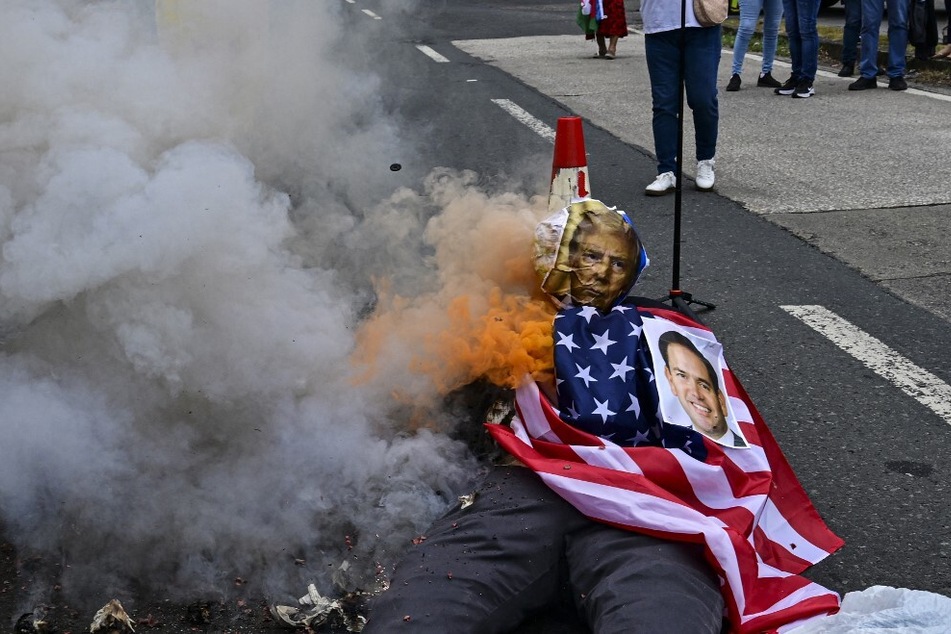 Demonstrators burn a rag doll with an US flag and the faces of President Donald Trump and Secretary of State Marco Rubio during a January 31, 2025, protest against Rubio's arrival in Panama City.