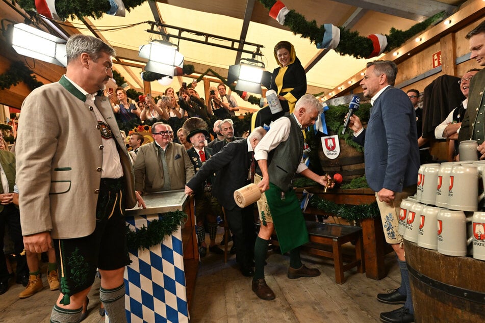 Dieter Reiter (66, SPD, 3.v.r), Oberbürgermeister von München, steht neben Markus Söder (57, CSU, l.), Ministerpräsident von Bayern, und sticht das erste Oktoberfestfass im Schottenhammel-Festzelt an.