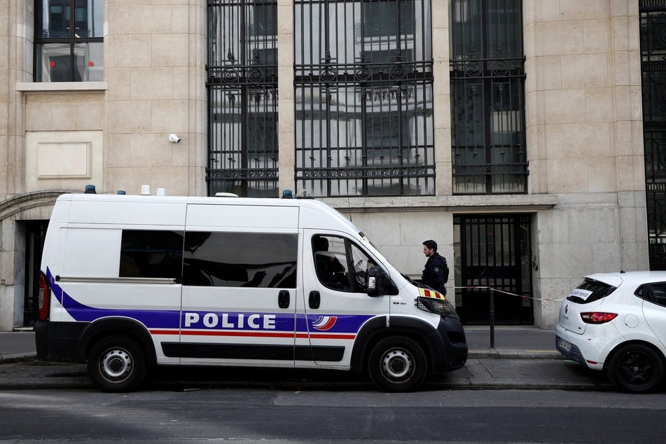 Police and private security vehicles are stationed outside the Bank of America building in the 8th arrondissement of Paris on March 28, 2026, following an apparent bomb attack attempt.
