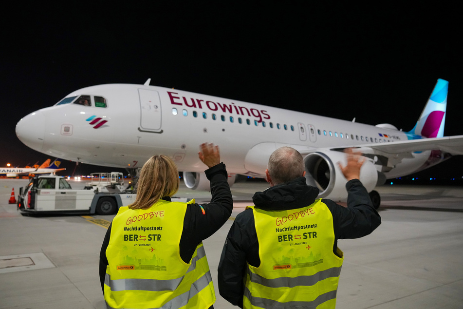 Mitarbeiter winken dem mit Post beladenem Airbus A320-214 zu, der Richtung Stuttgart startet.