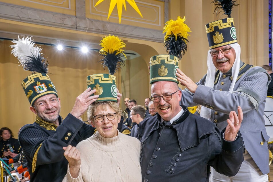 Grüezi und Glück auf: Vorsitzender Heiko Götze (56, l.) und 1. Schatzmeister Uwe Nitschke (70, r.) nehmen die Schweizer Anja und André Wössner in die Knappschaft auf.