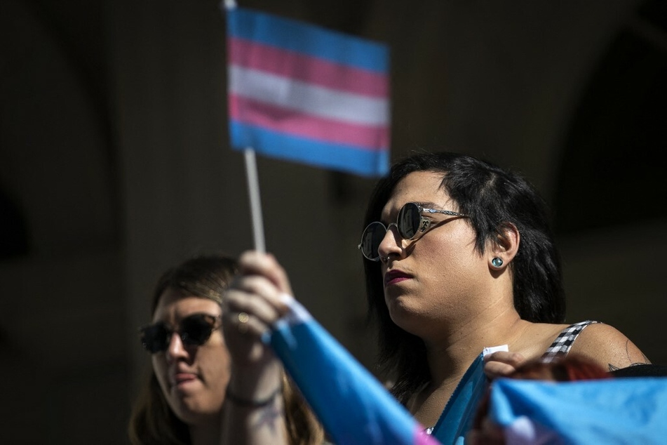 LGBTQ+ rights activists rally outside New York City Hall.