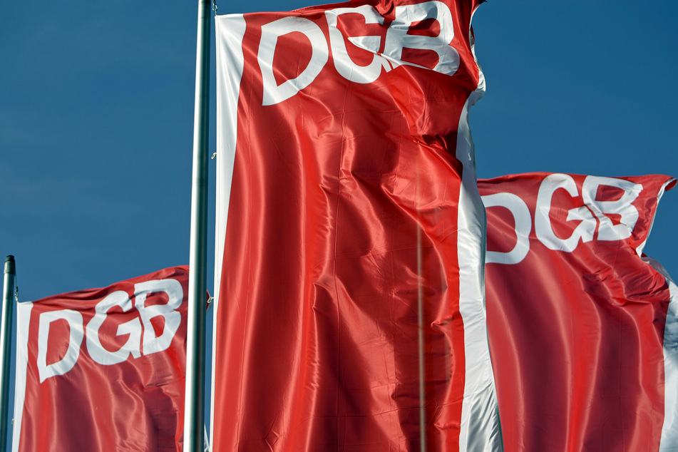 Fahnen des Deutschen Gewerkschaftsbunds (DGB) wehen vor dem blauen Himmel.
