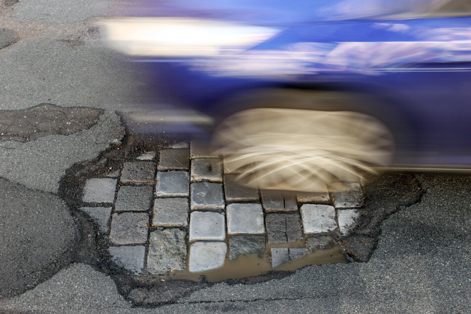 Ein Auto fährt über eine Straße mit Schlaglöchern. Mehr als ein Drittel der Staatsstraßen in Bayern sind marode. (Symbolbild)