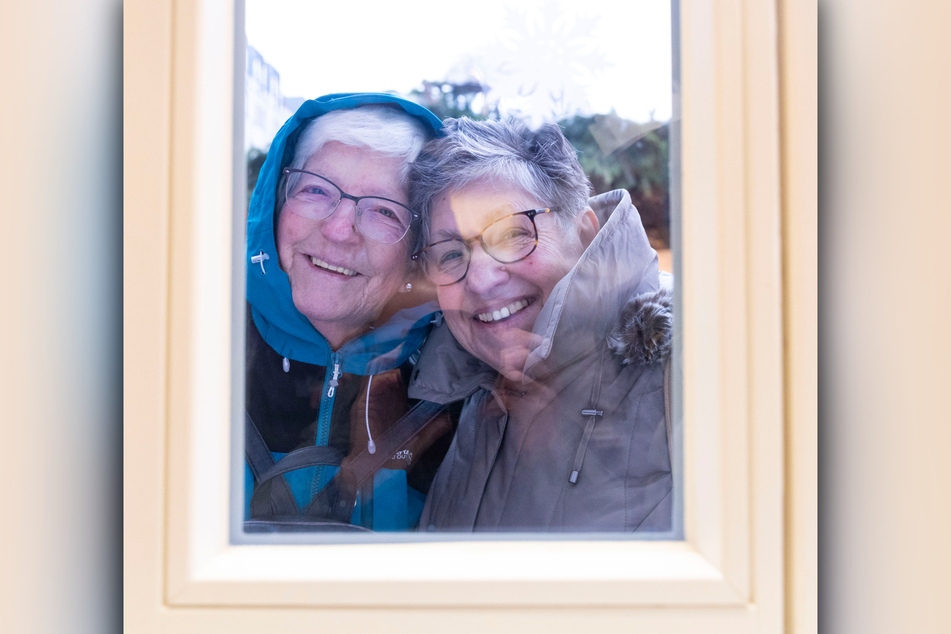 Seit 41 Jahren befreundet: Ursula Pink (77. l.) und Doris Melcher (73) aus Trier lächeln durch das Fenster der Weihnachtsbäckerei.