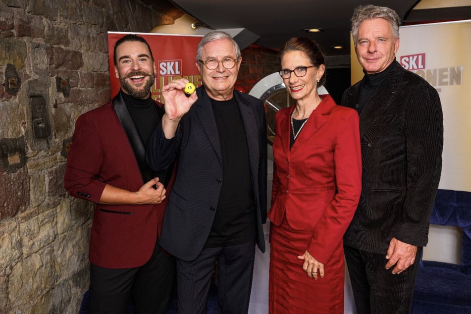 Moderator Eric Schroth (li.), Neu-Millionär Peter Koch (2. v. li.), Vorstandsvorsitzende der GKL Gemeinsame Klassenlotterie der Länder Dr. Bettina Rothärmel (2. v. re.) sowie Glückspate und SKL-Markenbotschafter Jörg Pilawa, (re.).