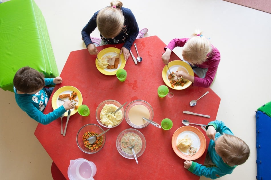 Kinder sitzen im Rahmen der Notbetreuung in einem Kindergarten während des Mittagessens an einem Tisch. (Symbolbild)