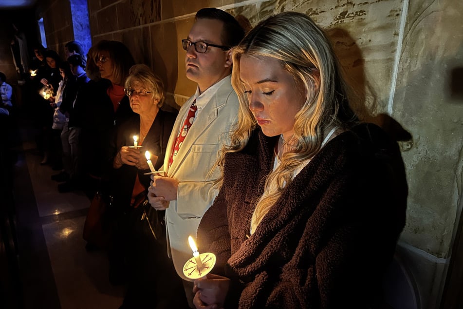 Gemeindemitglieder der katholischen Kirche St. Michaels in Memphis halten bei Stromausfall Kerzen während der Heiligabendmesse.