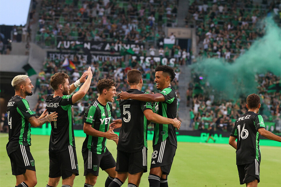 Austin FC players celebrate after scoring a goal against the Houston Dynamo at Q2 Stadium on August 4, 2021.