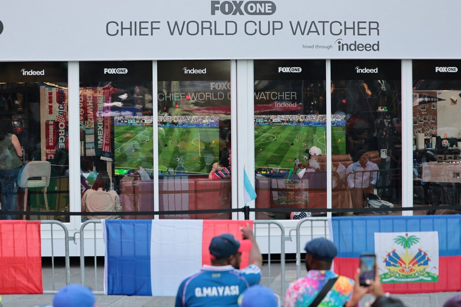 People look on as Austin Franklin and Kevin Akoto, FOX One Chief World Cup Watchers, watch the Senegal versus France World Cup match in Times Square on June 16, 2026.