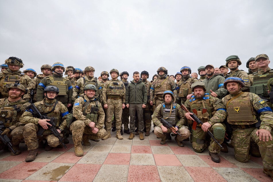 Ukrainian President Volodymyr Zelensky (c.) with members of his country's armed forces in the eastern city of Izyum.