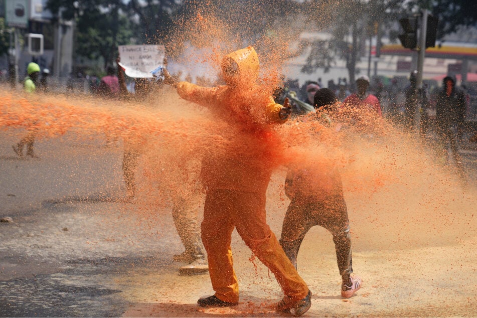 Demonstranten werden in der Innenstadt von der kenianischen Polizei während eines Protestes gegen geplante Steuererhöhungen mit Wasserkanonen bespritzt.