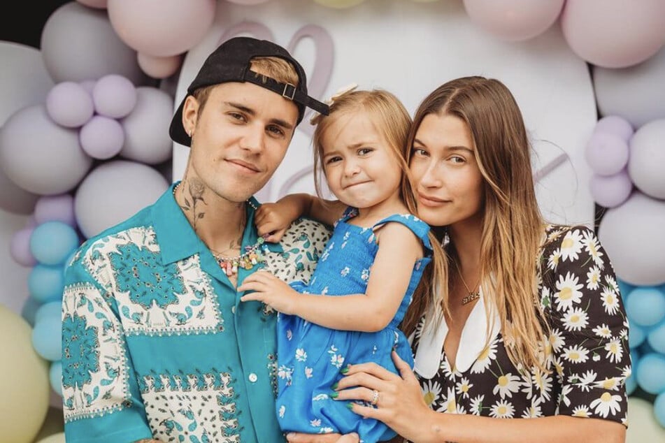 Justin Bieber poses with his wife, Hailey, and his younger sister.