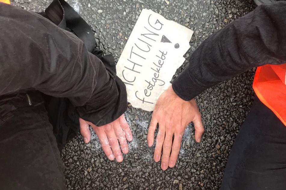Klimaaktivisten klebten sich im Zuge ihres Protests auf einer Fahrbahn in Wolfsburg fest. (Archivbild)