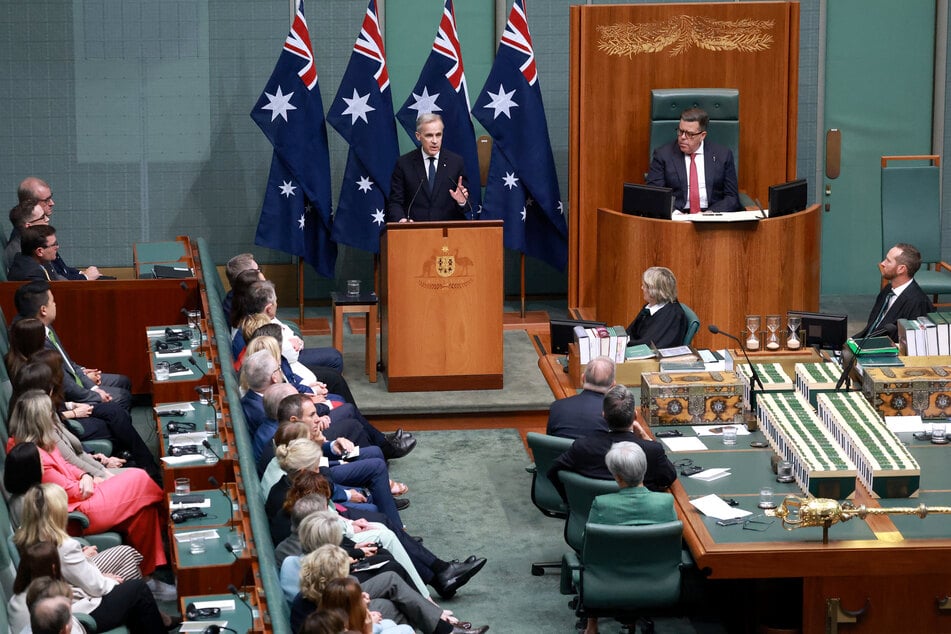 Canadian Prime Minister Mark Carney addresses Australia's parliament after being greeted by Australian Prime Minister Anthony Albanese and Opposition Leader Angus Taylor.