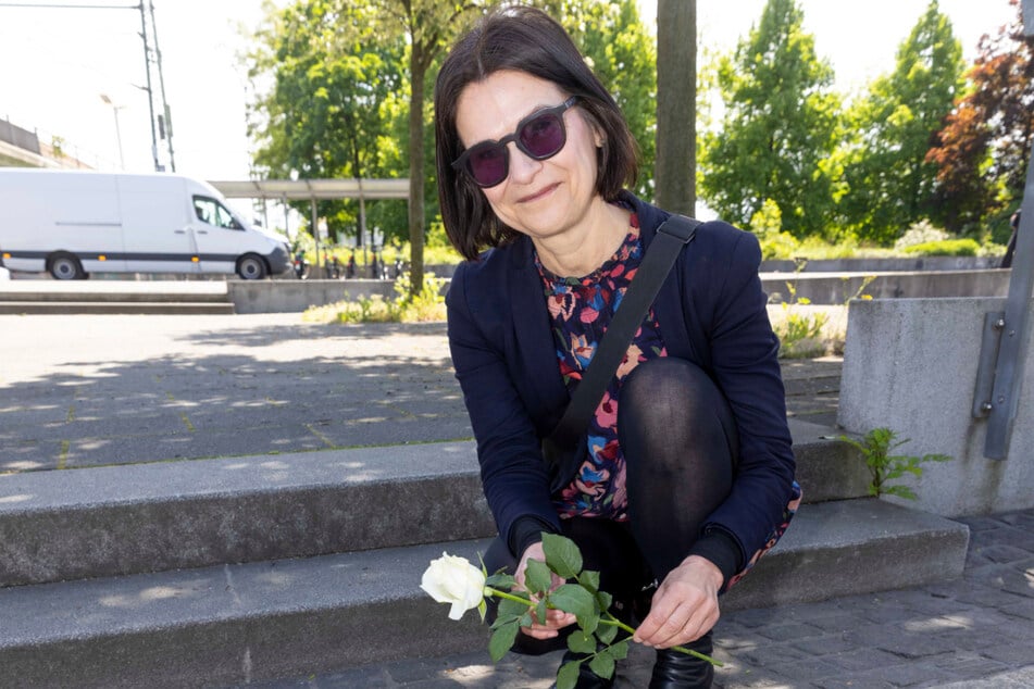 Birgit Sack, Leiterin der Gedenkstätte Münchner Platz, legt eine Rose auf den Stolperstein von Margarete Schreiber. Sie recherchierte über deren Leben.