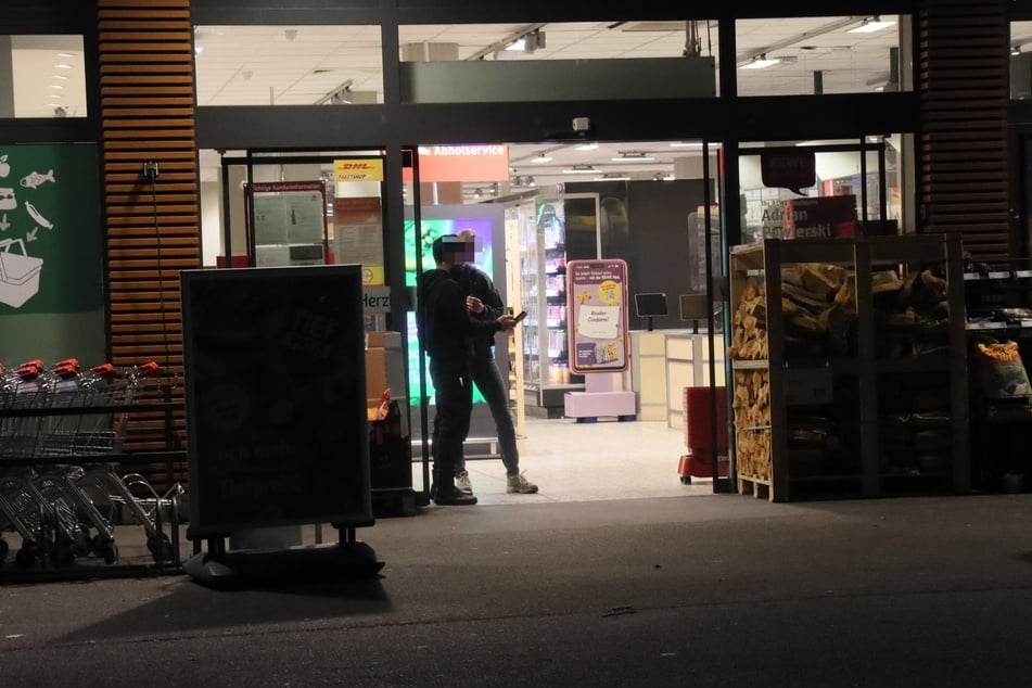 Beamte der Kriminalpolizei gehen die Tat mit einem Sicherheitsmitarbeiter durch.