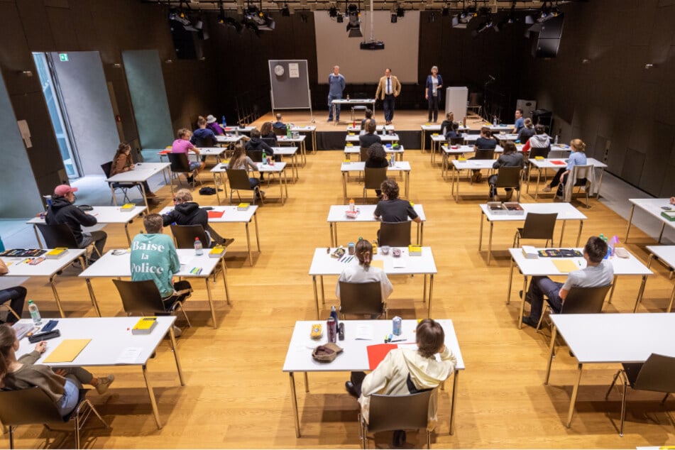 Mit weitem Abstand sitzen Schüler des Staatlichen Wilhelmsgymnasium in München zur Abiturprüfung in Deutsch an ihren Tischen in der Schulaula.