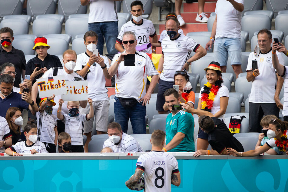 Deutschlands Toni Kroos (M.) steht nach dem Spiel bei Freunden, Familie und Fans. Nicht alle tragen eine FFP2-Maske.