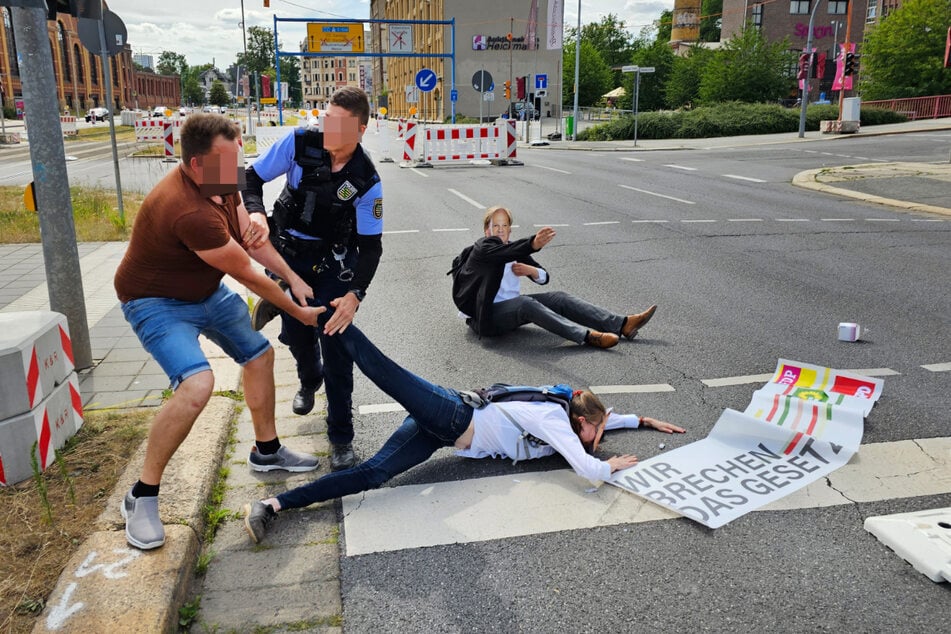 Bei der Klebe-Aktion wurde eine Aktivistin von einem wütenden Autofahrer von der Fahrbahn gezerrt.