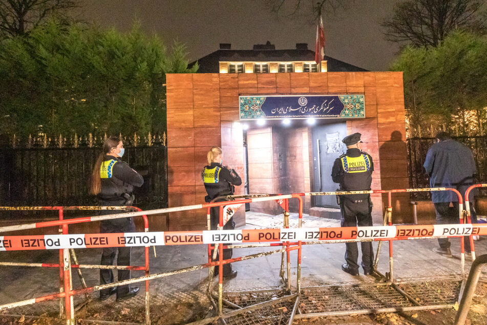 Polizeibeamte stehen vor dem iranischen Generalkonsulat, nachdem es dort einen Brandanschlag gegeben hat.