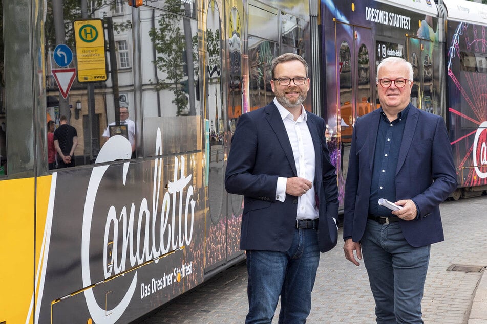 DVB-Verkehrsmanager Martin Gawalek (l.) und Event-Profi Frank Schröder freuen sich über die mobile Stadtfestwerbung auf der Straßenbahn.