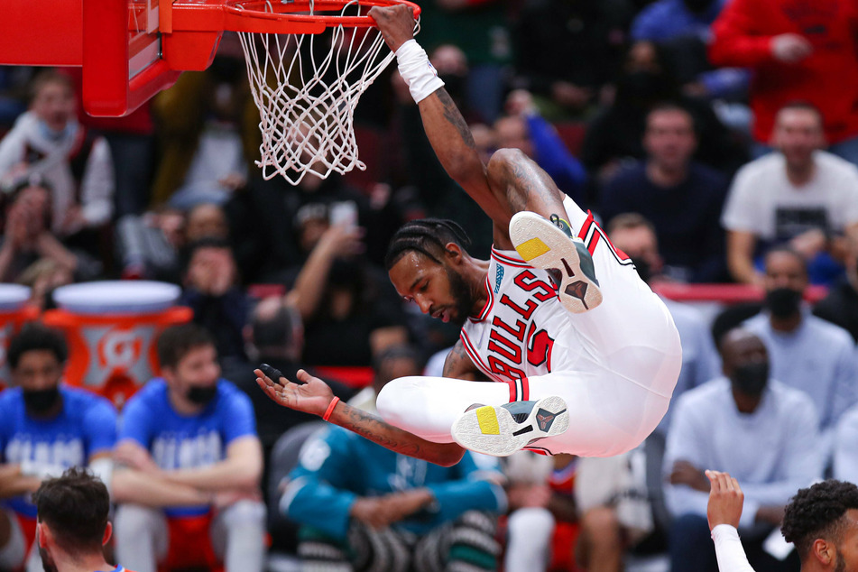 Chicago Bulls forward Derrick Jones Jr. hangs on the rim after dunking on the OKC Thunder.