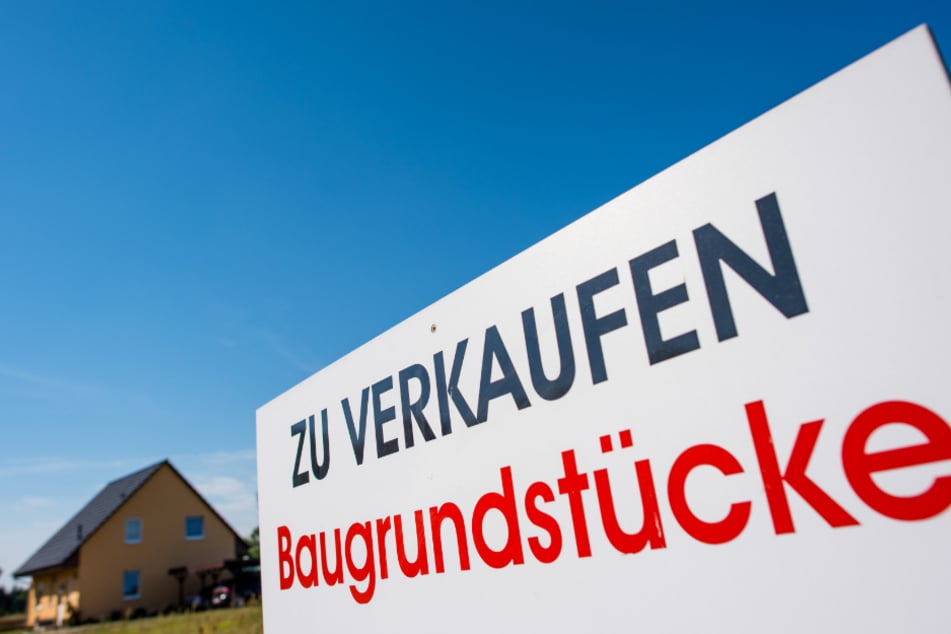 Ein Schild mit der Aufschrift «Zu verkaufen - Baugrundstücke» steht an einem Grundstück.