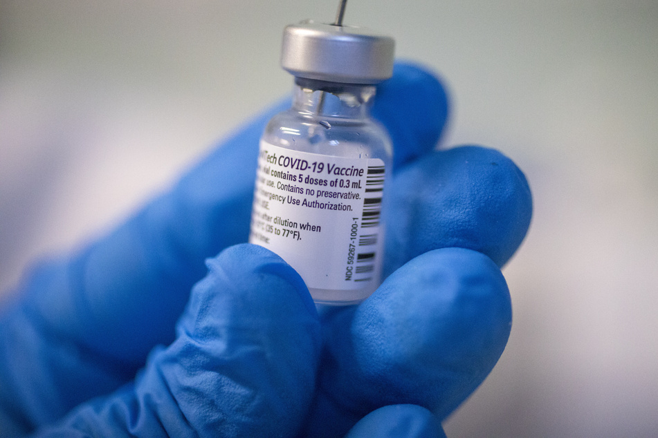 Ein Mitarbeiter des Gesundheitswesens bereitet mit Schutzhandschuhen den Corona-Impfstoff von Pfizer-Biontech vor. In einigen Ländern wird dieser bereits verwendet.