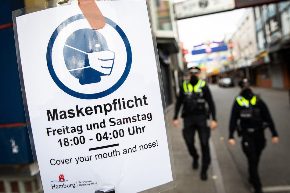 Ein Schild mit der Aufschrift "Maskenpflicht" hängt an der Reeperbahn.