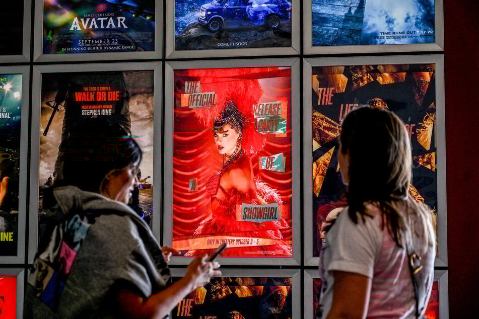 Fans take pictures in the lobby as they attend Taylor Swift: The Official Release Party of a Showgirl at AMC Montgomery 16 movie theater in Bethesda, Maryland, on October 3, 2025.