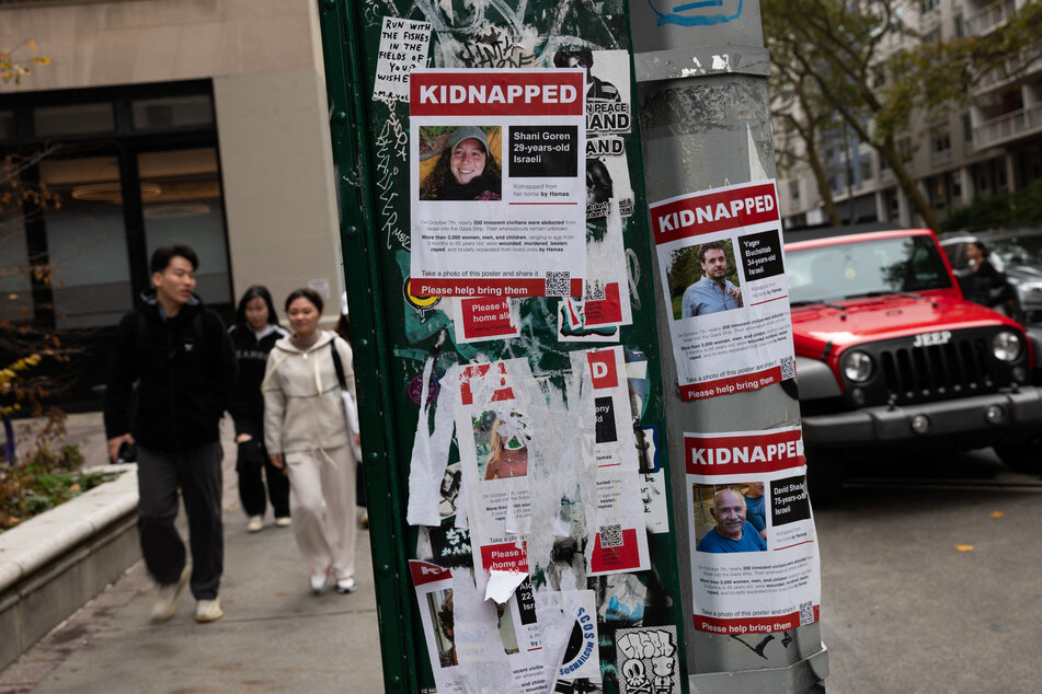 Defaced posters of some of those kidnapped by Hamas are displayed on a pole outside of New York University (NYU) in New York City.