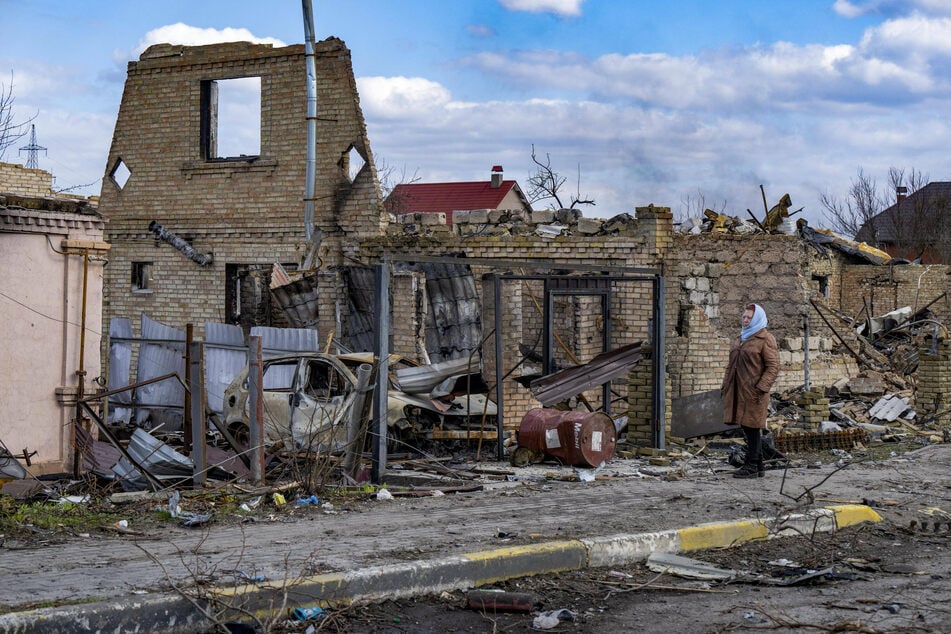 A resident of Bucha walks past destroyed buildings after Russia's withdrawal from the town.