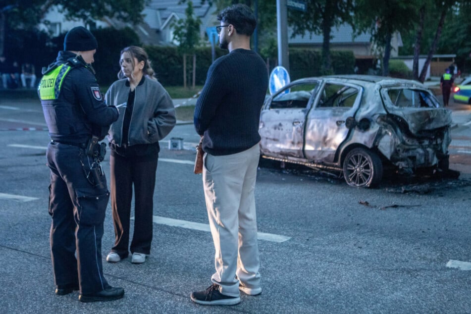 Ein Polizist nimmt vor Ort die Zeugenaussagen der Ersthelferin Sarah (17, M.) und eines Mannes auf.
