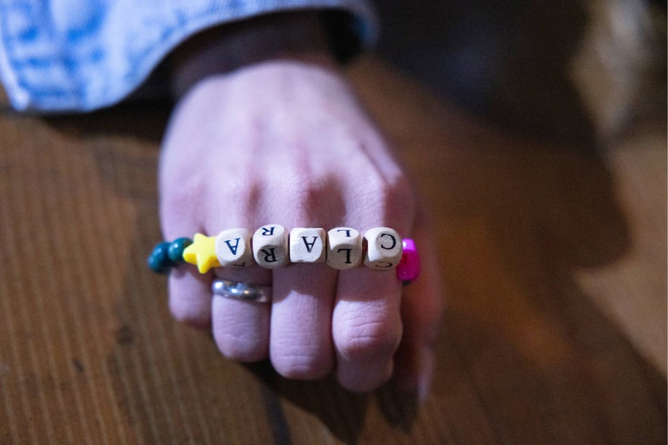 Zum Zeitpunkt ihres Ablebens hält Zoe ein Armband mit dem Namen ihrer Tochter in der Hand.