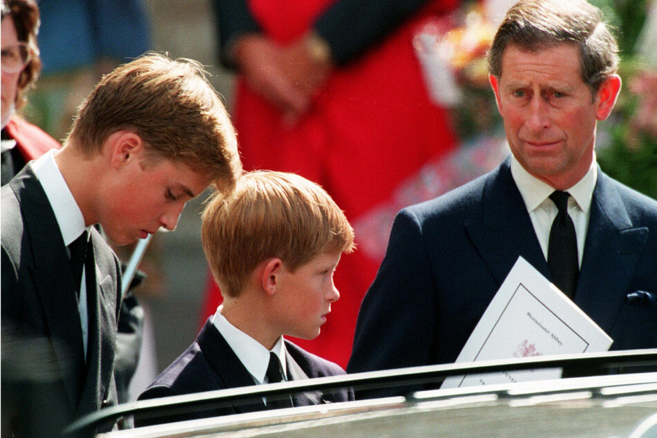 Prince Harry (c) discusses in his new memoir the night his father King Charles (r) told him Princess Diana had died.