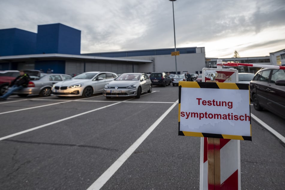 Im roten Warte-Bereich vor der Messe parken Autos dicht an dicht und mit offenen Fenstern. Fußgänger müssen frieren.