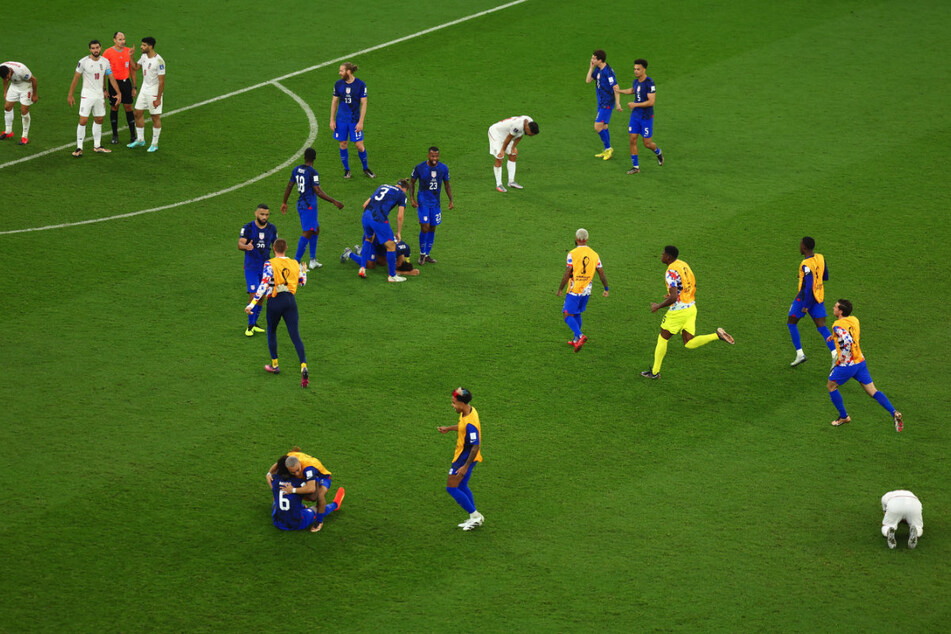 USMNT players celebrate at the end of their 1-0 win over Iran.