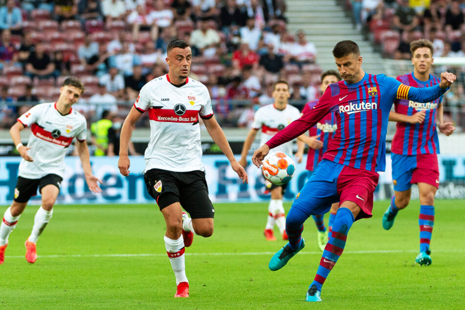 Barcelonas Kapitän Gerard Piqué (r.) klärt den Ball vor Stuttgarts Philipp Förster.