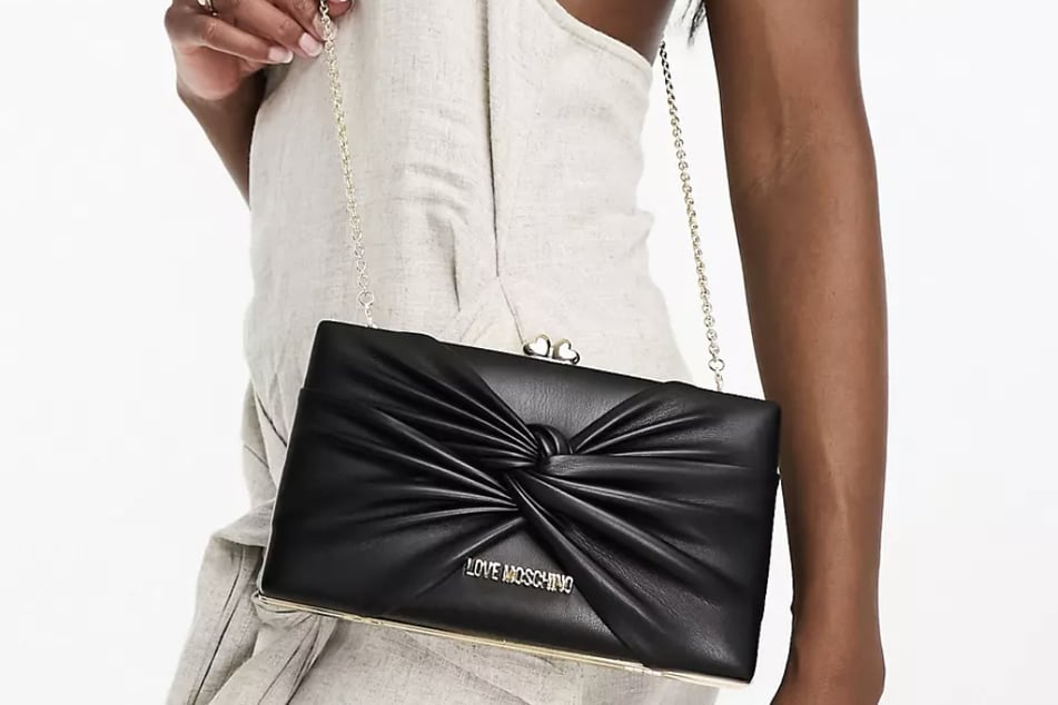 Die schwarze Clutch von ASOS lässt sich sowohl mit als auch ohne silbernen Kettengurt tragen.